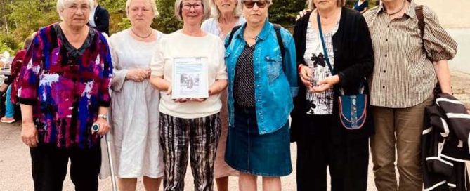 Grupp av kvinnor i varierande åldrar som ler och vinkar.