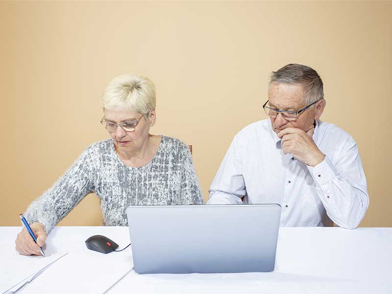 Kultur-och-samhällen-i-europa Två personer arbetar vid ett bord med en dator, papper och en mus.